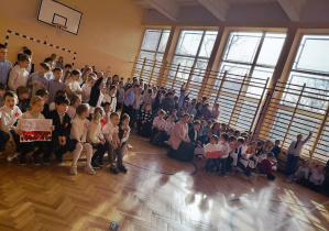 Uczniowie podczas akademii na sali gimnastycznej