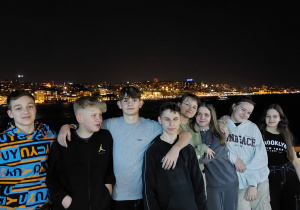 Uczniowie na tle nocnej panoramy jednego z miast w Turcji.