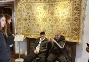 Uczniowie w Muzeum Dywanów na tle tureckiego dywanu.
