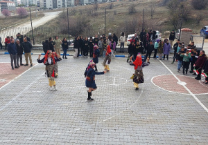 Pokaz przez gospodarzy tradycyjnego tańca tureckiego na boisku szkolnym.