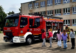 Wóz strażacki na placu przed szkołą.