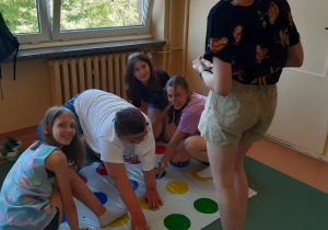 Uczniowie klas starszych grają w Twister.