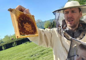 Pracownik pasieki opowiada o zwyczajach pszczół.