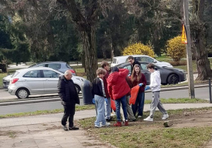 Uczniowie zbierają śmieci.