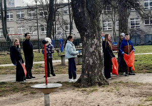 Uczniowie zbierają śmieci.